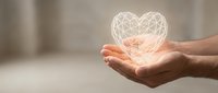 Hands gently holding glowing geometric heart symbol representing love, care, compassion and emotional wellness in soft warm lighting for healthcare concepts.