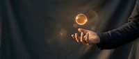 Businessman holding glowing golden sphere with light energy, representing innovation, success, and business growth potential for corporate concepts.