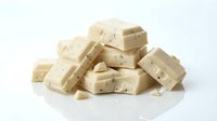 Stacked white chocolate chunks with holes isolated on white background, ready for food and confectionery design projects.