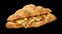 Croissant sandwich with scrambled eggs and bacon filling, isolated on transparent background. Ready for menu design, food packaging, restaurant graphics, t-shirt prints, and digital culinary projects.