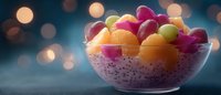Colorful melon balls and dragon fruit in glass bowl with chia pudding against blurred bokeh lights background, healthy breakfast or dessert serving.