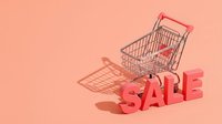 Shopping cart with bold sale text on a pastel pink background, casting soft shadows, perfect for retail promotions and discount campaigns.