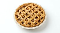 Freshly baked fruit pie with golden lattice crust in white ceramic dish, isolated on white background for food photography, bakery, and culinary design use.