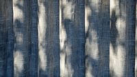 Abstract vertical pattern with white blurred shapes on textured denim blue background creates dynamic movement and depth, suitable for modern interior design projects.