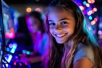 Young Hispanic woman smiling at night club with colorful neon lights and bokeh effects in background, expressing joy and happiness while enjoying nightlife atmosphere.