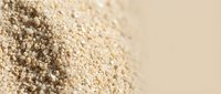 Organic quinoa seeds pile with shallow depth of field on neutral background for healthy cooking and nutrition concepts.