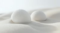 Minimalist white spheres on soft wavy surface create serene zen composition with gentle shadows and curves, suitable for wellness and spa marketing.