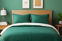 Modern bedroom interior with emerald green bedding, wooden headboard and nightstand against dark green wall, minimalist decor and potted plant.
