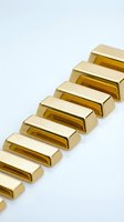 Row of shiny golden bars arranged diagonally on white background representing wealth investment precious metal bullion financial security concept.