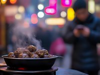 Steaming hot meatballs in cast background with colorful bokeh lights and silhouette of person using smartphone.