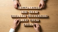 Hands arranging wooden blocks with compliance, ISO 9001, quality assurance, risk management and audit text on wooden surface for business standards and regulatory requirements.