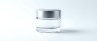 Empty glass cosmetic jar with silver lid on white background for skincare product packaging and beauty brand mockup design.