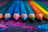 Vibrant colored pencils arranged in row with colorful dust and shavings scattered on dark background, macro photography showing detailed wood texture and pigment detail.