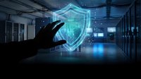 Hand holding glowing digital security shield hologram in modern data center server room with blue lighting for cybersecurity protection concepts.
