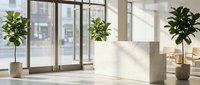 Modern office reception desk with green plants in bright workspace interior with large windows and natural sunlight creating professional atmosphere.