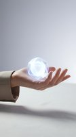 Business hand holding glowing crystal sphere with magical light effects for technology innovation and future concepts.