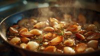 Aromatic garlic cloves roasting in hot oil with herbs, creating a flavorful base for gourmet cooking.