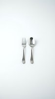 Stainless steel fork and spoon set isolated on white background for kitchen dining restaurant culinary design projects.