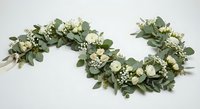 Elegant eucalyptus garland with white roses and baby's breath flowers for wedding decoration, bridal shower, or romantic event styling on white background.