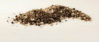 Crushed black pepper spice pile isolated on white background for culinary seasoning and cooking ingredient applications.