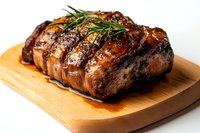 Juicy grilled beef steak with rosemary garnish and glaze sauce on wooden cutting board, close up view showing meat texture and caramelized surface.