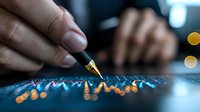 Close-up of financial analyst examining market data chart with golden pen point, blue graph line with orange bokeh lights creating analytical mood.