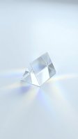 Clear crystal prism refracting rainbow light spectrum on white background creating colorful optical dispersion effect for science education and design projects.