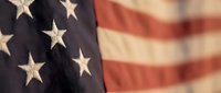 Close-up of American flag with stars and stripes showing patriotic symbols for Memorial Day, Independence Day, Veterans Day celebrations and national pride.
