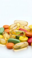 Colorful vitamin supplements and omega-3 fish oil capsules scattered on white background for health and wellness nutrition concepts.