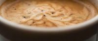 Creamy hummus with sesame seeds and spices in a white bowl, ready for serving as a healthy appetizer or dip for Mediterranean cuisine.