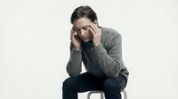 Middle-aged Caucasian man experiencing severe headache holding temples in pain wearing gray sweater isolated on white background for health concepts.