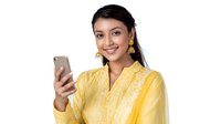 Young South Asian woman in bright yellow traditional embroidered dress holding smartphone and smiling at camera, professional business portrait on white background.