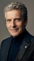 Mature man with gray hair wearing dark blazer and navy turtleneck against neutral background. Professional headshot suitable for corporate, business, and executive portraits.