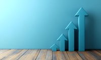 Growing blue arrows on wooden floor against turquoise wall showing upward trend, progress and business growth concept for financial presentations.