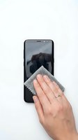 Hand cleaning smartphone screen with microfiber cloth on white background. Isolated device maintenance and care concept for tech support, electronics cleaning, and gadget protection.