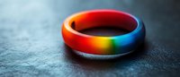 Rainbow colored silicone ring on dark textured background with soft focus and dramatic lighting, symbolizing unity, diversity and pride in modern jewelry design.