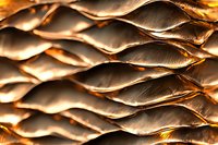 Abstract metallic wave pattern in copper and gold tones creating dimensional surface texture with dramatic lighting and shadow effects for luxury backgrounds.