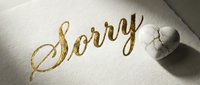 Elegant gold calligraphy Sorry text on white paper with a cracked marble heart, symbolizing apology, forgiveness, and emotional healing in relationships.