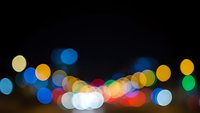 Abstract colorful bokeh lights on black background creating dreamy atmosphere for holiday celebrations, party events, and festive decorations.