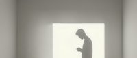 Silhouette of man using smartphone in minimalist white interior space with natural lighting for modern technology and communication concepts.