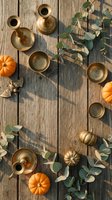 Autumn flat lay with brass candlesticks, orange pumpkins and eucalyptus branches on rustic wooden background for seasonal home decor and thanksgiving styling.