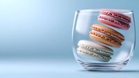 Colorful macarons floating in clear glass against blue background, creative food photography with minimalist composition and soft lighting for pastry advertising.
