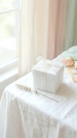 White gift box with ribbon on linen tablecloth near window with soft natural light and lavender sprig for romantic occasions and celebrations.