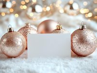 Rose gold Christmas baubles on white snow with blank card for text, festive bokeh lights background creates magical holiday atmosphere.
