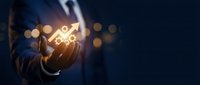 Businessman holding glowing lightbulb with innovation icons representing creative ideas and business solutions in corporate environment.