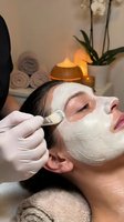 Professional spa facial treatment with white clay mask application by skilled aesthetician in luxury wellness center for skincare and relaxation.