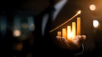 Businessman holding glowing financial growth chart in dark environment, symbolizing success, investment strategy, and market analysis.