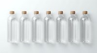 Seven clear glass bottles with cork stoppers arranged in row on white background for packaging design and branding projects.