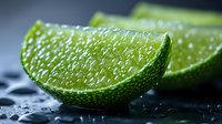 Fresh lime wedges with water drops on dark background, extreme close up macro shot showing citrus flesh texture and vibrant green peel. Food photography for cocktails.