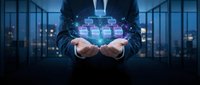 Businessman holding digital network interface with glowing icons above hands in modern office environment, representing cloud computing and data connectivity.
